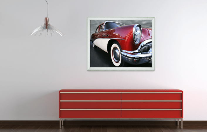 Aluminium Gallery Frame 8880 in silver matt colour, with picture of old timer car, placed in interior with red cupboard and a lamp. Picture frame producer Debex Suisse AG.