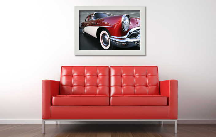 Aluminium Poster Frame Sideloader Modern Y830 in silver matt color, with poster of old timer car, placed in interior with red sofa. Picture frame producer Debex Suisse.