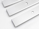 Close-up of three white flat metal bars with pre-drilled holes